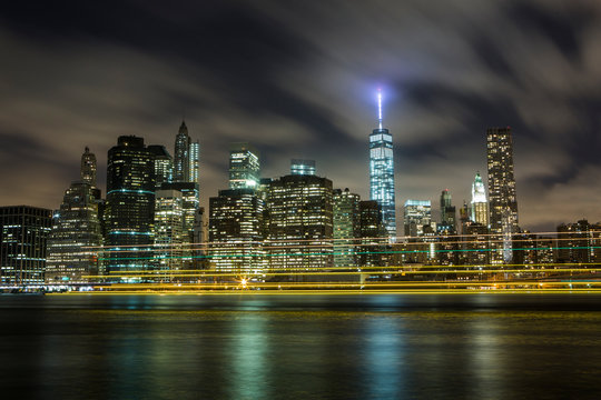 Ferry lights pass by New York's Freedom Tower on the East River.