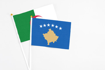 Kosovo and Algeria stick flags on white background. High quality fabric, miniature national flag. Peaceful global concept.White floor for copy space.
