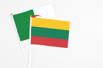 Lithuania and Algeria stick flags on white background. High quality fabric, miniature national flag. Peaceful global concept.White floor for copy space.