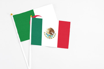 Mexico and Algeria stick flags on white background. High quality fabric, miniature national flag. Peaceful global concept.White floor for copy space.