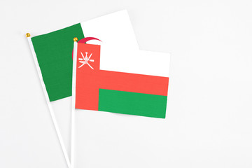 Oman and Algeria stick flags on white background. High quality fabric, miniature national flag. Peaceful global concept.White floor for copy space.