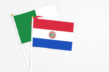 Paraguay and Algeria stick flags on white background. High quality fabric, miniature national flag. Peaceful global concept.White floor for copy space.