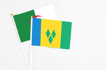 Saint Vincent And The Grenadines and Algeria stick flags on white background. High quality fabric, miniature national flag. Peaceful global concept.White floor for copy space.