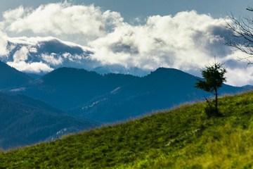 HDR photo of the Tatra Mountains and Great Giewont Peak with the steel Cross between clouds.