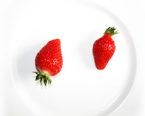 Fresh strawberries isolated on the white plate.