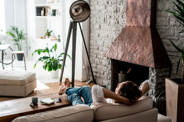 Relaxed man leaning back on couch at home