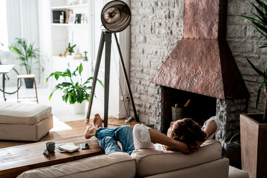 Relaxed man leaning back on couch at home