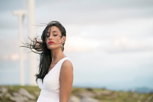 Young woman wearing white dress, looking arrogant