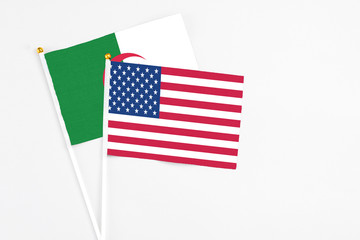 United States and Algeria stick flags on white background. High quality fabric, miniature national flag. Peaceful global concept.White floor for copy space.