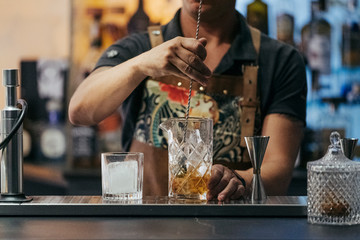 Fototapeta na wymiar Bartender mixing cocktail in a bar