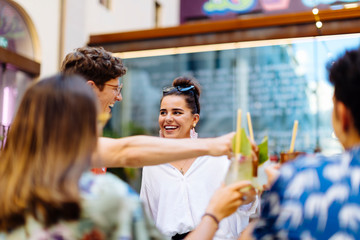 Happy multi-ethnic friends toasting drinks