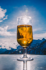 Glass of beer with the Serre Chevalier Alps in the background, France