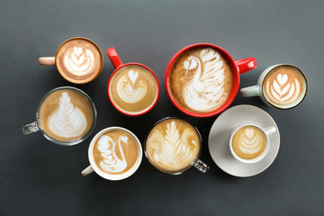Buch of coffee cups with different kind of beverage and different latte art foam designs. Top view, close up, copy space, background.