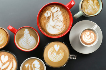 Buch of coffee cups with different kind of beverage and different latte art foam designs. Top view, close up, copy space, background.