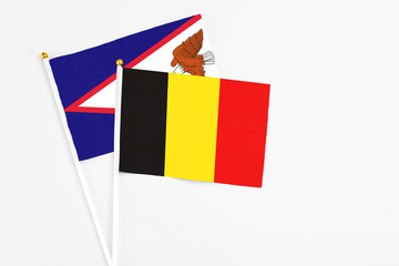 Belgium and American Samoa stick flags on white background. High quality fabric, miniature national flag. Peaceful global concept.White floor for copy space.