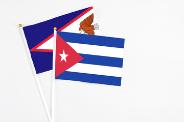 Cuba and American Samoa stick flags on white background. High quality fabric, miniature national flag. Peaceful global concept.White floor for copy space.