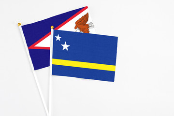 Curacao and American Samoa stick flags on white background. High quality fabric, miniature national flag. Peaceful global concept.White floor for copy space.