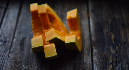 ripe orange pumpkin sliced on a wooden table