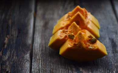 ripe orange pumpkin sliced on a wooden table