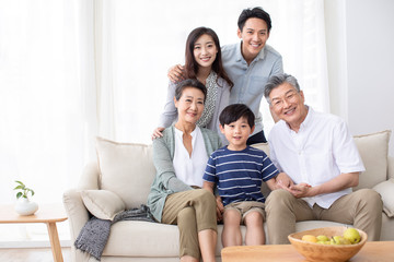 Happy Chinese family relaxing on sofa