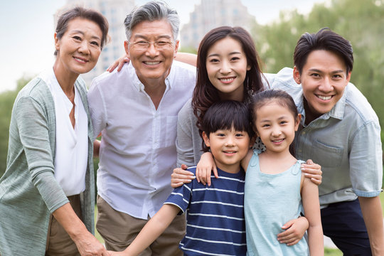 Happy Chinese family standing on grass