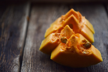 ripe orange pumpkin sliced on a wooden table