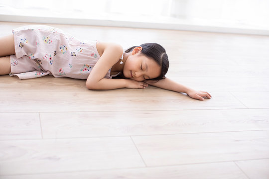 Little Chinese girl lying on floor