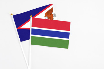 Gambia and American Samoa stick flags on white background. High quality fabric, miniature national flag. Peaceful global concept.White floor for copy space.