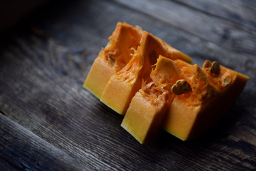 ripe orange pumpkin sliced on a wooden table