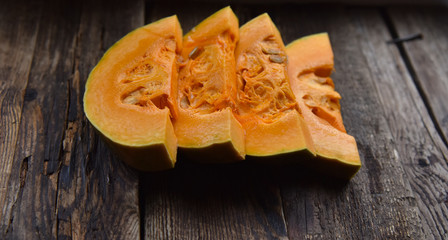 ripe orange pumpkin sliced on a wooden table