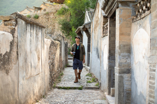 Chinese photographer walking in village