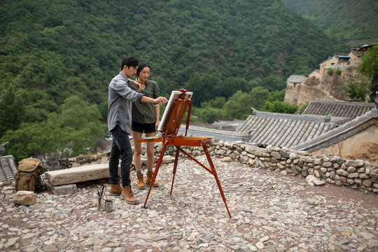 Young Chinese couple painting outdoors
