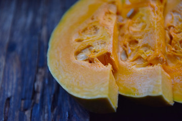 ripe orange pumpkin sliced on a wooden table
