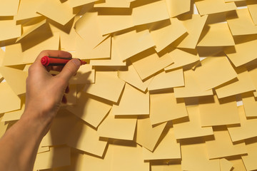 Hand writes on the wall with sticky notes. Post memo business people.