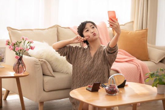 Young Chinese woman doing live webcast at home