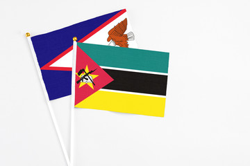 Mozambique and American Samoa stick flags on white background. High quality fabric, miniature national flag. Peaceful global concept.White floor for copy space.