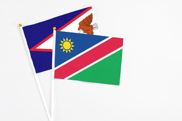 Namibia and American Samoa stick flags on white background. High quality fabric, miniature national flag. Peaceful global concept.White floor for copy space.