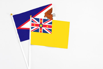 Niue and American Samoa stick flags on white background. High quality fabric, miniature national...