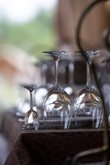 Different types of inverted empty glasses for wine on the wooden table