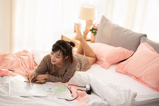 Young Chinese woman making travel plan at home