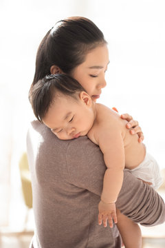 Young Chinese mom holding baby girl