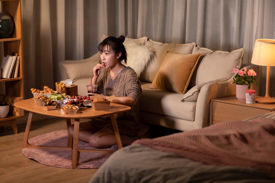 Young Chinese woman eating take-out food at night