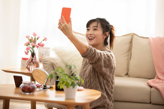 Young Chinese woman doing live webcast at home