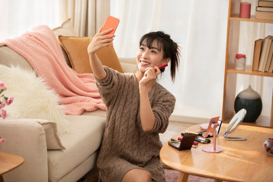 Young Chinese woman doing live webcast at home
