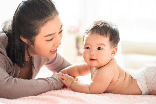 Young Chinese mom taking care of baby girl