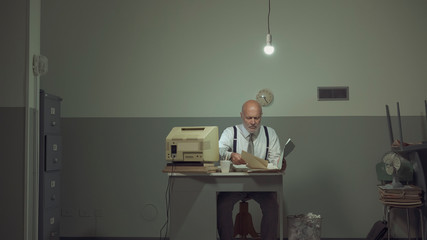 Sad businessman working in a small office