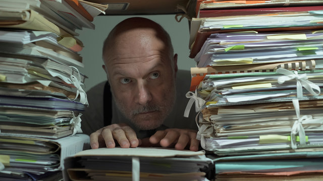 Creepy office clerk overloaded with paperwork