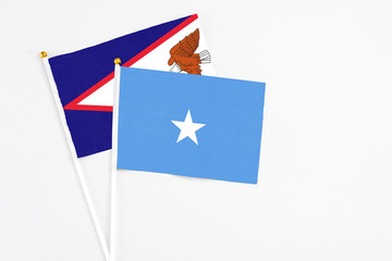 Somalia and American Samoa stick flags on white background. High quality fabric, miniature national flag. Peaceful global concept.White floor for copy space.