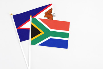 South Africa and American Samoa stick flags on white background. High quality fabric, miniature national flag. Peaceful global concept.White floor for copy space.