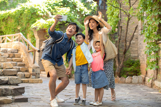 Young Chinese family taking selfie outdoors